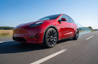 A modified Tesla Model Y featuring 20-inch custom forged wheels parked outdoors.